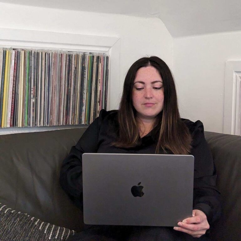 Alana holding a laptop in front of her